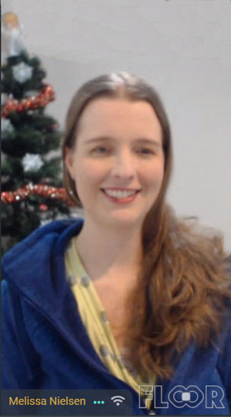Picture of Melissa Nielsen in front of her Christmas tree, smiling.
